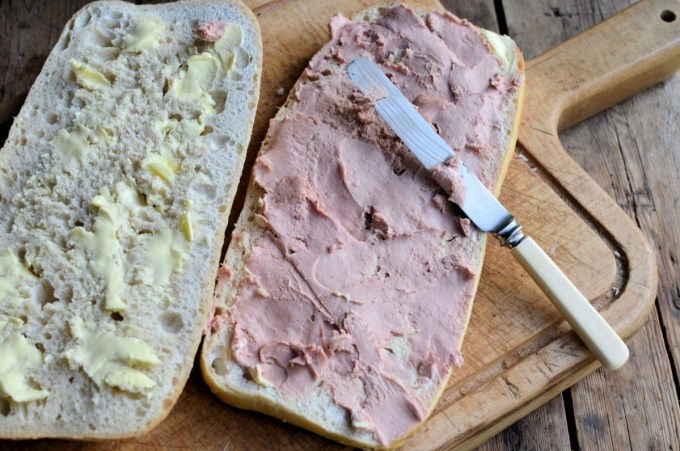 Method: 1. Cut the loaf of bread in half as seen in the photos. 2. Spread both halves of the bread with the butter and then layer up the ingredients on one half of the bread loaf in the order listed – see the photos. 3. Place the lid on top of the filling and then wrap in greaseproof paper and tie with some string. 4. Place some heavy books or weights on top and leave for at least 12 to 24 hours, in a cool place. 5. Serve in slices.